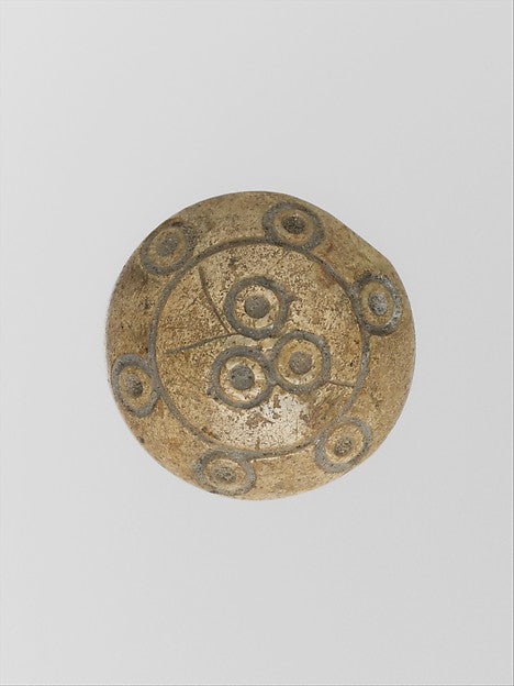 A Roman bone gaming counter, a small round playing disc of the kind used in ludus latrunculorum.