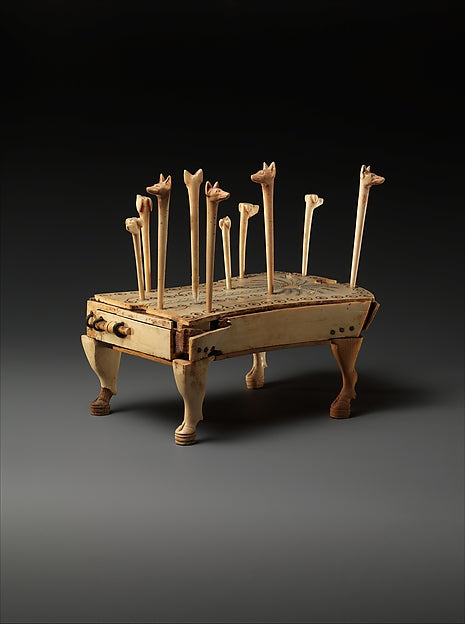 Ancient Egyptian Game of Hounds and Jackals: a shrine-shaped ebony and ivory board with two rows of small holes and slender pegs carved with hound and jackal heads, Middle Kingdom, ca. 1814–1805 B.C., Metropolitan Museum of Art.