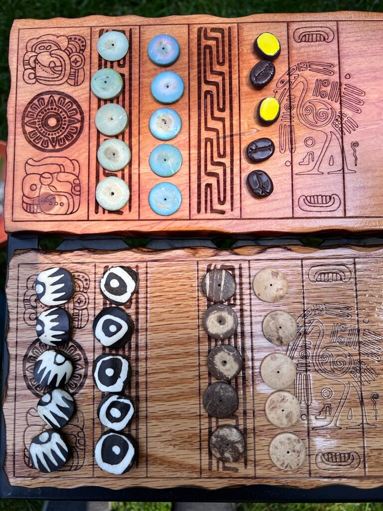 Handcrafted wooden Bul (Puluc) board, a Maya Mesoamerican running-fight game, with a segmented track and small stackable counters.
